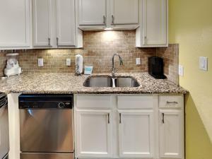 a kitchen with white cabinets and a sink at Seaside Delight in Mustang Beach +31 photos