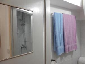 a bathroom with purple and blue towels and a mirror at Studio In Einem Traditionellen Steinhaus, In Baska in Baška