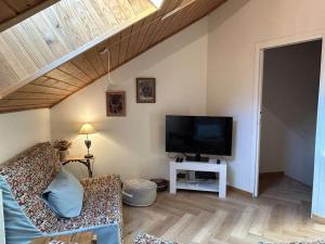a living room with a couch and a flat screen tv at Triplex chaleureux 6 pax avec wifi et parking, Chantemerle, Serre-Chevalier - FR-1-330E-17 in Serre Chevalier