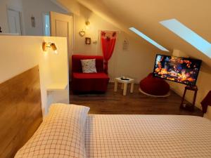 a bedroom with a bed and a tv and a couch at Le Grenier Apartment in Turin