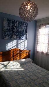 une chambre avec un lit et un lustre dans l'établissement Edelweiss - Grust, Panoramique Sud, à Grust