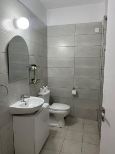 a bathroom with a toilet and a sink and a mirror at Almyria Apartments - By NOMA STAYS Cyprus in Paphos +56 photos