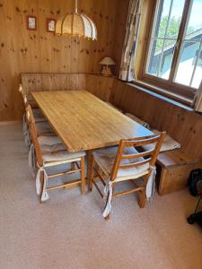 a wooden table and two chairs in a room at Ferienwohnung Caziela 49 in Tschappina