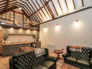 Una sala de estar con dos sofás de cuero y una mesa. en Dotty's Den, en Bridlington