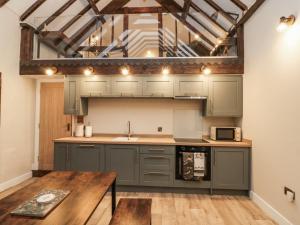 Una cocina con gabinetes grises y una mesa de madera. en Dotty's Den, en Bridlington 16 fotos más