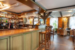 a bar in a restaurant with a counter and chairs at Kjøbmandsgaarden Hotel in Mandal +37 photos