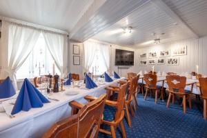 a dining room with long tables and chairs at Kjøbmandsgaarden Hotel in Mandal