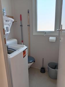 ein kleines Badezimmer mit Toilette und Fenster in der Unterkunft MH 229 2 chambres et 1 salle de bain dans camping 4 étoiles avec parc aquatique in Saint-Julien-en-Born