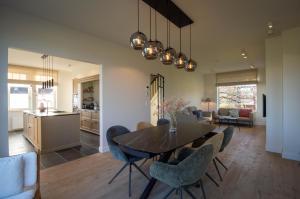 a dining room and kitchen with a table and chairs at Villa Magnolia B&B in Oostkamp
