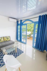 a living room with blue curtains and a couch at CLUB IBIZA - Party Hotel & Beach Club in Jacó