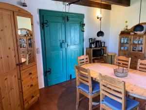 a dining room with a blue door and a table and chairs at Ferienhaus Kranich In Ummanz Lüßvitz in Ummanz