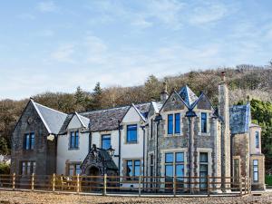 une grande maison avec une clôture devant dans l'établissement 9 Bed in Porthmadog 90740, à Talsarnau