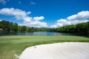 a golf course with a lake in the background at Whispering Knoll - Jasper, GA - Enjoy Peaceful Forest Views, Settle in for Movie Night in the Private Theater Room, Stay Active in Jasper +2 photos