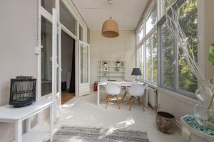 a living room with a table and chairs and windows at Westersingel in Rotterdam
