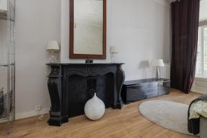 a living room with a black fireplace and a mirror at Westersingel in Rotterdam