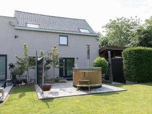 a backyard with a hot tub and a house at Casa-Anja in Zingem