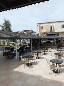 a man standing on a patio with tables and chairs at Amphi Apart in Marmaris +16 photos