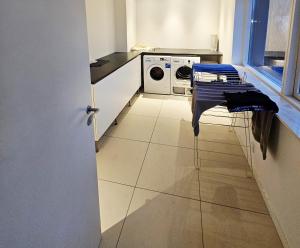 Una cocina con lavadora y secadora en una habitación. en Easy stay, en Glostrup