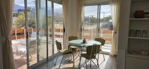 ein Zimmer mit Tisch und Stühlen und einem Balkon in der Unterkunft Vistas del Yásta cabaña para un solo grupo in Cafayate