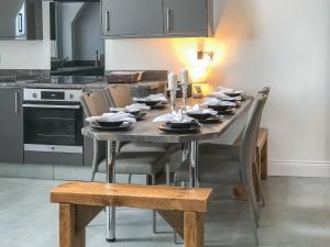 a dining room table with chairs and a kitchen at Sea View Penthouse - Regency Mansion in Redcar