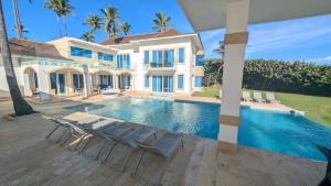 a villa with a swimming pool in front of a house at Peninsula Esmeralda Luxury Hotel & Villas in San Felipe de Puerto Plata