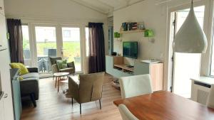 a kitchen and living room with a table and chairs at Saffier Zuid-Limburg in Simpelveld
