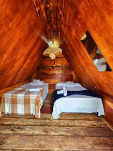 ein Zimmer mit zwei Betten in einer Holzhütte in der Unterkunft Pousada Recanto da Gê in Buíque