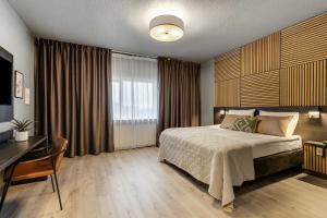 Un dormitorio con una cama y un escritorio y una ventana. en Konvin Hotel by Reykjavik Keflavik Airport, en Keflavík