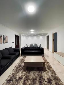 Sala de estar con sofá negro y mesa de centro en Coze Suite Nile River, en El Cairo 1 foto más
