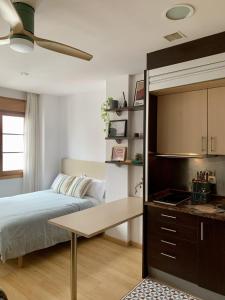 ein Schlafzimmer mit einem Bett, einem Schreibtisch und einem Tisch in der Unterkunft Apartamentos Marques de Teverga , Oviedo centro in Oviedo