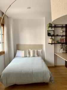 a bedroom with a bed with a white bedspread at Apartamentos Marques de Teverga , Oviedo centro in Oviedo