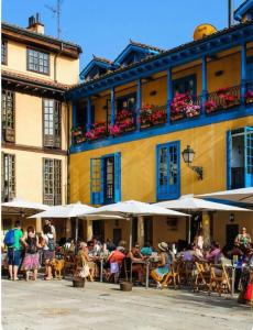 eine Gruppe von Menschen, die an Tischen vor einem Gebäude sitzen in der Unterkunft Apartamentos Marques de Teverga , Oviedo centro in Oviedo + 63 Fotos