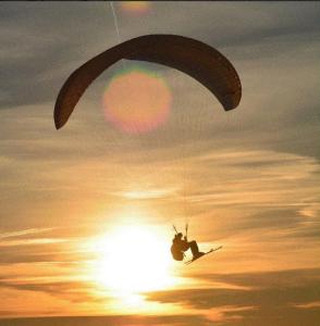 una persona sugli sci che vola in aria con un paracadute di L'aube de Vouglans 2 Personnes a Pont-de-Poitte Altre 8 foto