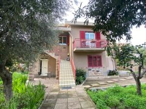 een huis met een rode deur en een balkon bij La Luna Sarda, Bosa in Bosa Marina
