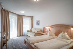 Habitación de hotel con cama y sofá en Alpenresidenz am Mühlbach en Obergurgl