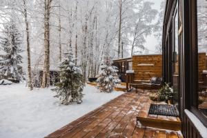 une terrasse enneigée avec une cabane dans l'établissement Aava Riverside, à Rovaniemi