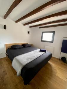 ein Schlafzimmer mit einem Bett in einem Zimmer mit Holzboden in der Unterkunft Le petit Corum - HH - Centre historique in Montpellier