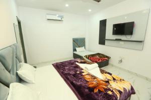 Habitación hospitalaria con cama y TV en Aditya Home Stay, en Amritsar