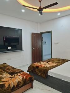 Un dormitorio con dos camas y un televisor de pantalla plana. en Aditya Home Stay, en Amritsar