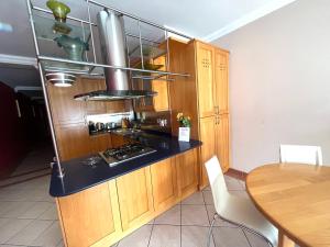 梅利哈Beach Apartment - Classic room with Terrace的厨房配有木制橱柜、炉灶和桌子。