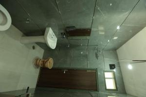 Un baño con inodoro, lavabo y espejo. en Aditya Home Stay, en Amritsar