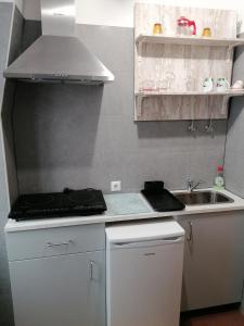 eine kleine Küche mit Spüle und Herd in der Unterkunft A casinha in Nazaré + 4 Fotos