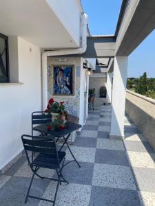 a patio with a table and chairs on a tile floor at Laviniahouse Nettuno in Nettuno