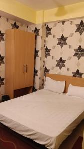 Un dormitorio con una cama grande con sábanas blancas. en Magadh Kutumb Guest House, en Patna 7 fotos más