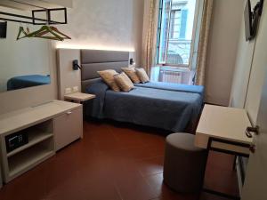 a small bedroom with a bed with pillows on it at Hotel Tourist House in Florence