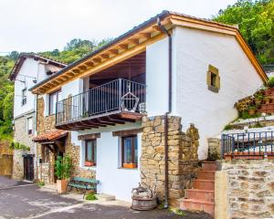 ein weißes Haus mit einem Balkon und einer Treppe in der Unterkunft El Mirador de Armaño G-10235 in Armaño