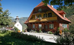 Una gran casa de madera con una torre y un edificio. en Die Kromarin, en Kleinsölk