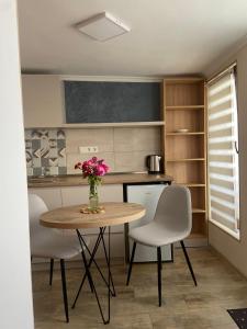 a kitchen with a table with chairs and a vase of flowers at Maganiskhedi in Mtskheta
