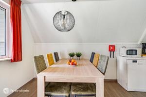 une table de salle à manger avec un bol de fruits dessus dans l'établissement Mooie rustige woning Overijssel, à Gramsbergen
