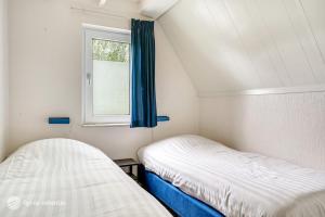 deux lits dans une petite pièce avec une fenêtre dans l'établissement Mooie rustige woning Overijssel, à Gramsbergen 22 autres photos